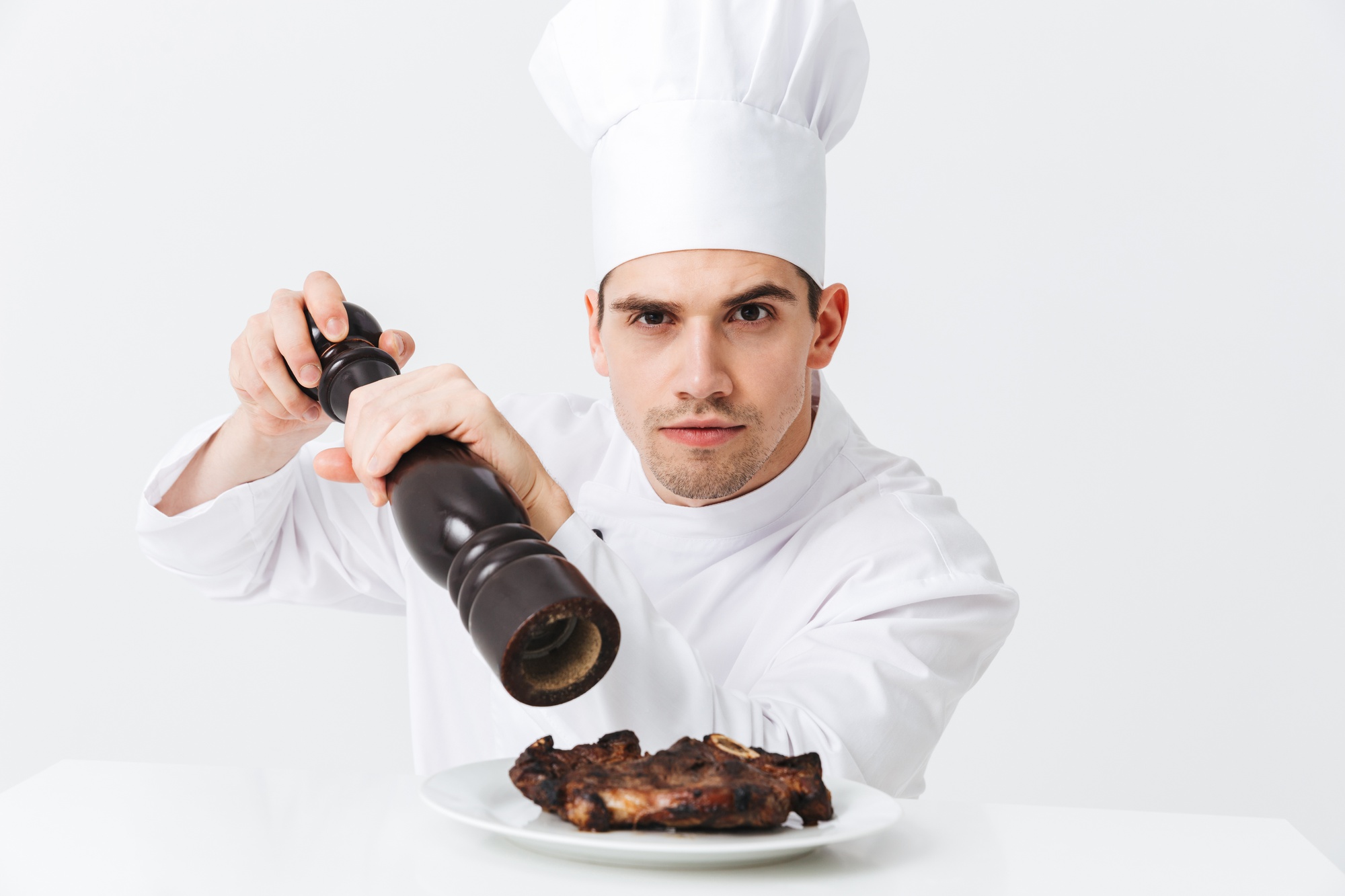 Chef searing meat in kitchen