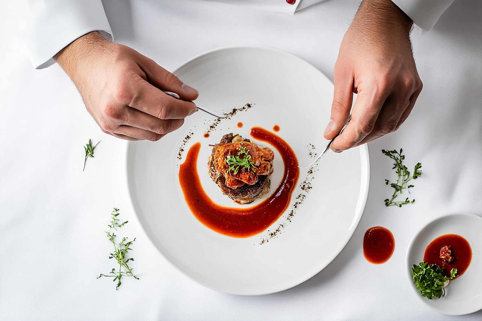 Chef arranging plated gourmet dish